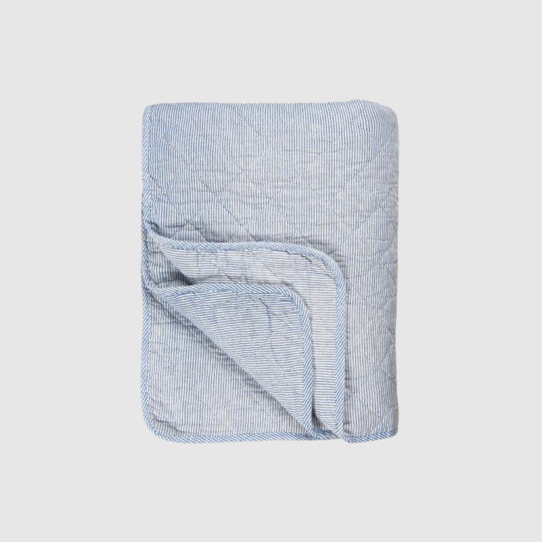 Opdag den klassiske quilt med hvide og blå mælkedrengestriber fra Ib Laursen – et smukt og hyggeligt tæppe i blød bomuld med quiltet struktur. Den tidløse kombination af blå og hvid giver et rent, nordisk look, som passer perfekt i stuen, soveværelset eller sommerhuset. Brug den som plaid, sengetæppe, picnic‑tæppe eller som ekstra hygge på terrassen.