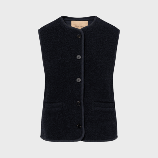 Mørk navy uldvest med rund hals og knapper – CAS TEDDY fra Rue de Tokyo, bæres over grå strik af model på 175 cm.