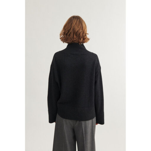 Modellen bærer Cady T-neck sweater i bæredygtig uldblanding – farve: Dark Grey Mel.