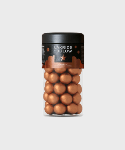 Lakrids by Bülow Classic Caramel Regular: Søde lakridsperler overtrukket med dulce chokolade og et strejf af havsalt. Køb hos Merci-Give.