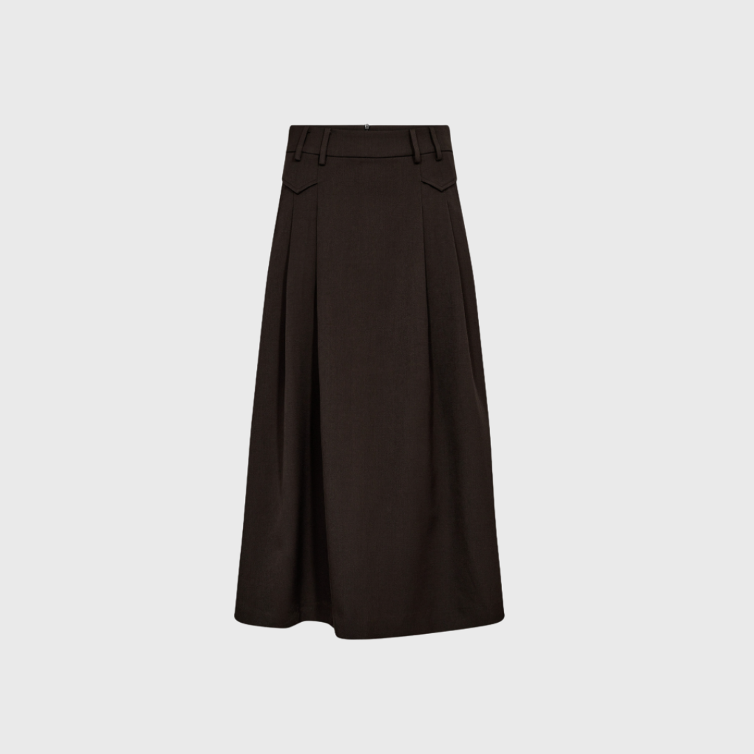 Skab et stilfuldt og moderne look med Luna Pocket Pleat nederdelen fra Co'Couture. Den mørkebrune midi-nederdel har et flatterende A-snit, fine læg og lommedetaljer, som giver kant og elegance. Perfekt til både kontor og hverdagsbrug – et alsidigt valg til den moderne garderobe. Shop den hos Merci Give.
