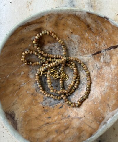 Annavii Reena Halskæde i Brown Mel er en smuk, håndlavet glasperlekæde i en varm brun, meleret farvetone. Perfekt alene eller i lag‑på‑lag styling, og ideel til både hverdag og pæne outfits. Et elegant og tidløst smykke med et unikt håndlavet udtryk.