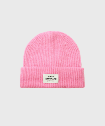 Tosca Anju Hat fra Mads Nørgaard er en moderne og blød ribstrikket hue med bredt ombuk og logolabel foran. Her i en frisk fuchsia pink farve, der tilføjer farve og personlighed til dit vinterlook. Huen er fremstillet i en varm og komfortabel uldblanding og passer perfekt til både hverdag og udendørs aktiviteter. Køb din hue hos Merci Give og få hurtig levering og personlig service.