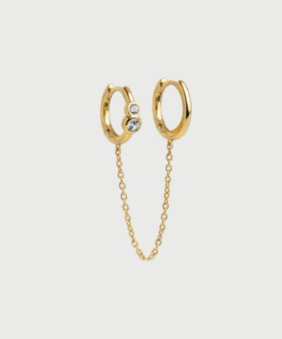 Nova Chain Hoops fra ENAMEL Copenhagen – en kreativ og moderne ørering med dobbelt hoop-design og kæde. Fremstillet i 18 karat guldbelagt sterlingsølv med klare zirkonia-sten. Perfekt til dig med to huller i samme øre, der ønsker et anderledes og elegant udtryk. Køb hos Merci Give med hurtig levering og fri fragt over 499 DKK.