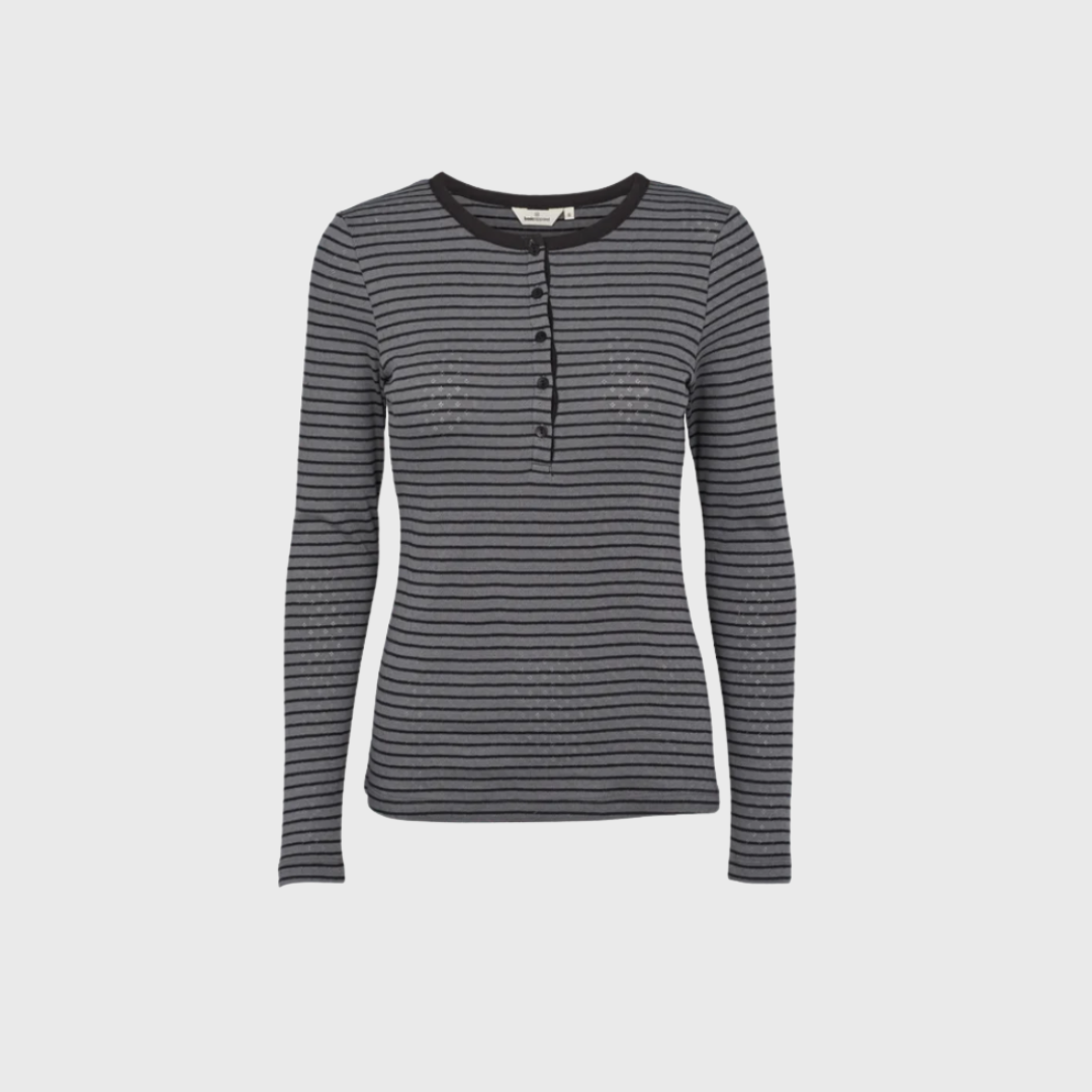 Opdag den tidløse Basic Apparel Arense Stripe Granddad T-shirt i Poppy Seed/Black – en klassiker til garderoben. Fremstillet i 100% økologisk bomuld for maksimal komfort og bæredygtighed. Det stribede design og granddad-hals med knapper giver et afslappet og stilrent look, perfekt til både hverdag og lag-på-lag styling.