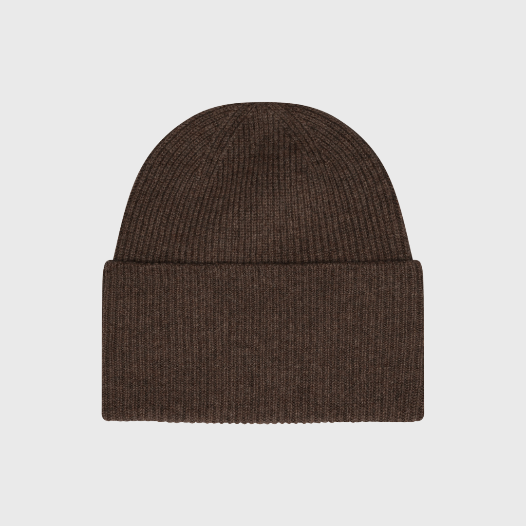 Frau Basel Cashmere Beanie i farven Acorn er den perfekte vinteraccessory til dig, der ønsker luksus og komfort. Huen er strikket i 100% cashmere, hvilket giver en utrolig blød og varm kvalitet. Det tidløse ribstrikkede design sikrer en klassisk pasform, der passer til alle outfits. Ideel til både hverdag og kolde vinterdage.