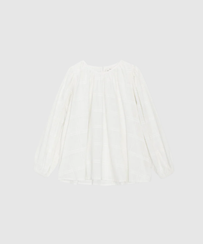 Opdag Faithful Top Dobby Check fra Moshi Moshi Mind – en let og feminin bluse i certificeret økologisk bomuld. Den fine dobby‑struktur, ballonærmerne og de rynkede detaljer giver et romantisk, men moderne look. Farven Off White gør blusen nem at style til både hverdag, arbejde og sæsonens pænere outfits. En smuk, ansvarligt produceret basic‑favorit.