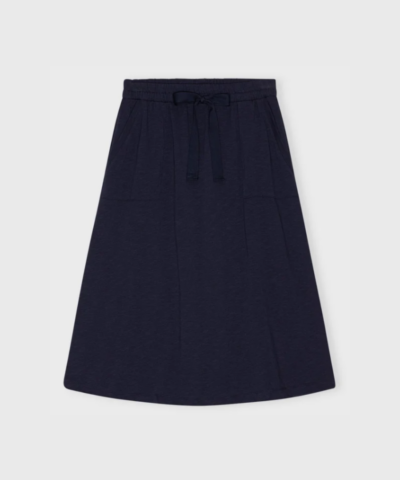 Opdag den elegante Halo Skirt fra Moshi Moshi Mind i farven Dark Navy – en tidløs nederdel med A-form, elastik i taljen og smukt fald. Fremstillet i økologisk bomuld for maksimal komfort og bæredygtighed. Perfekt til både hverdag og fest. Skandinavisk design med fokus på stil og velvære.