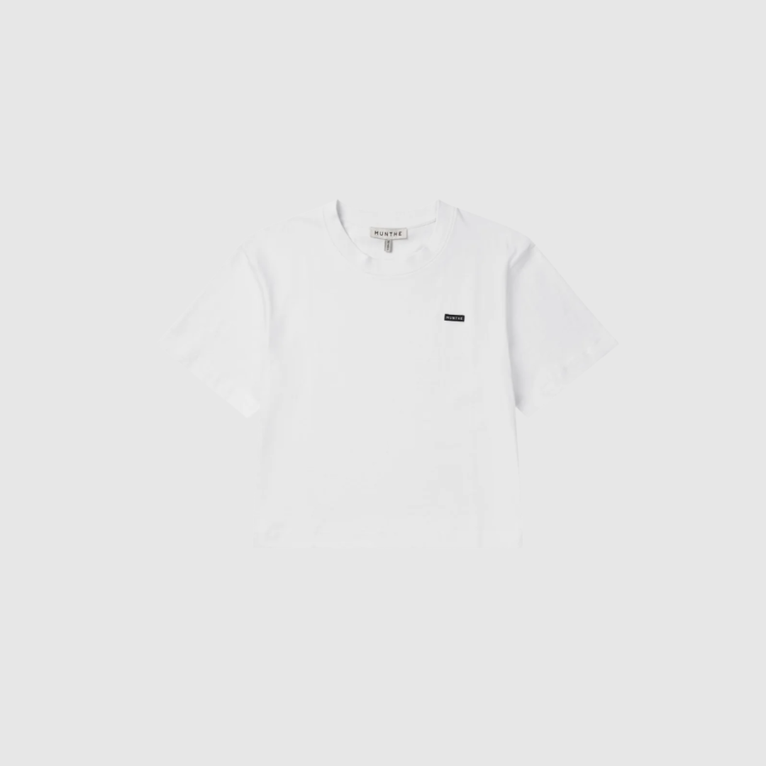 Opdag BELLAMY T-Shirt – White, en cropped T-shirt i 100% økologisk bomuld med diskret logo. Designet med loose fit, rund hals og korte ærmer for et afslappet og moderne look. Perfekt til både hverdag og casual styling – fremstillet med omtanke for kvalitet og miljø.