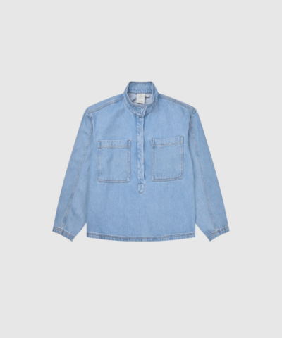 Opdag Tuxa Top – Light Blue, en smuk denimskjorte i 100% Tencel™. De oversize brystlommer og den halve knapstolpe giver skjorten et moderne og karakterfuldt look, mens det bløde materiale sikrer en behagelig pasform. Perfekt til både hverdagsbrug og mere stilfulde outfits – og smuk både alene og som del af et denim‑sæt med Tuxya Skirt.
