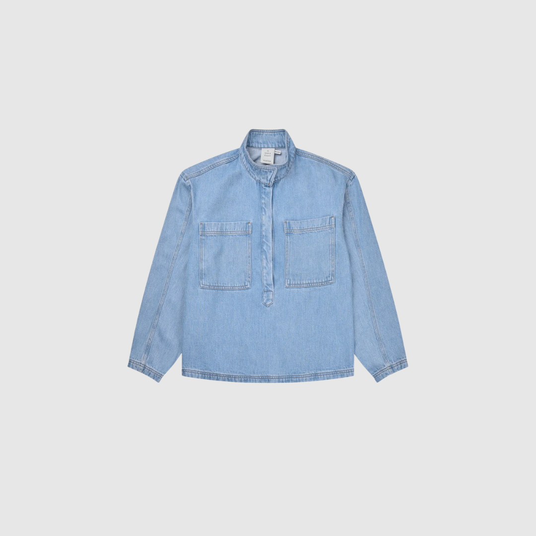 Opdag Tuxa Top – Light Blue, en smuk denimskjorte i 100% Tencel™. De oversize brystlommer og den halve knapstolpe giver skjorten et moderne og karakterfuldt look, mens det bløde materiale sikrer en behagelig pasform. Perfekt til både hverdagsbrug og mere stilfulde outfits – og smuk både alene og som del af et denim‑sæt med Tuxya Skirt.