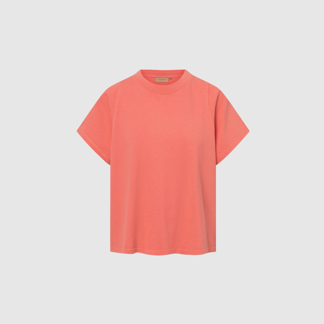 Opgrader din basisgarderobe med TEAGAN LIGHT GMTD JERSEY fra Rue de Tokyo i den tidløse farve Coral Red. Denne bløde T-shirt i 100% bomuld kombinerer komfort, kvalitet og et minimalistisk design, der gør den ideel til både hverdag og pænere stylinger. De korte raglanærmer og relaxed fit giver et moderne og afslappet udtryk, som er nemt at matche med både jeans, shorts, nederdele og lag-på-lag looks. En uundværlig basicstyle, der holder sæson efter sæson.