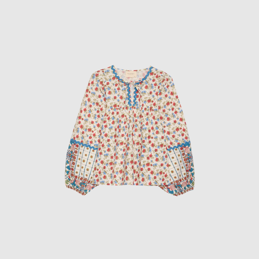Opdag Coral Top fra Sissel Edelbo – en romantisk, farverig top i 100% økologisk bomuld. Det vintageinspirerede print kombineret med zigzag‑bånd, ballonærmer og tie‑strings skaber et feminint og unikt look. Farven Rooster giver varme og personlighed, perfekt til både hverdagsbrug og sæsonens festlige outfits.