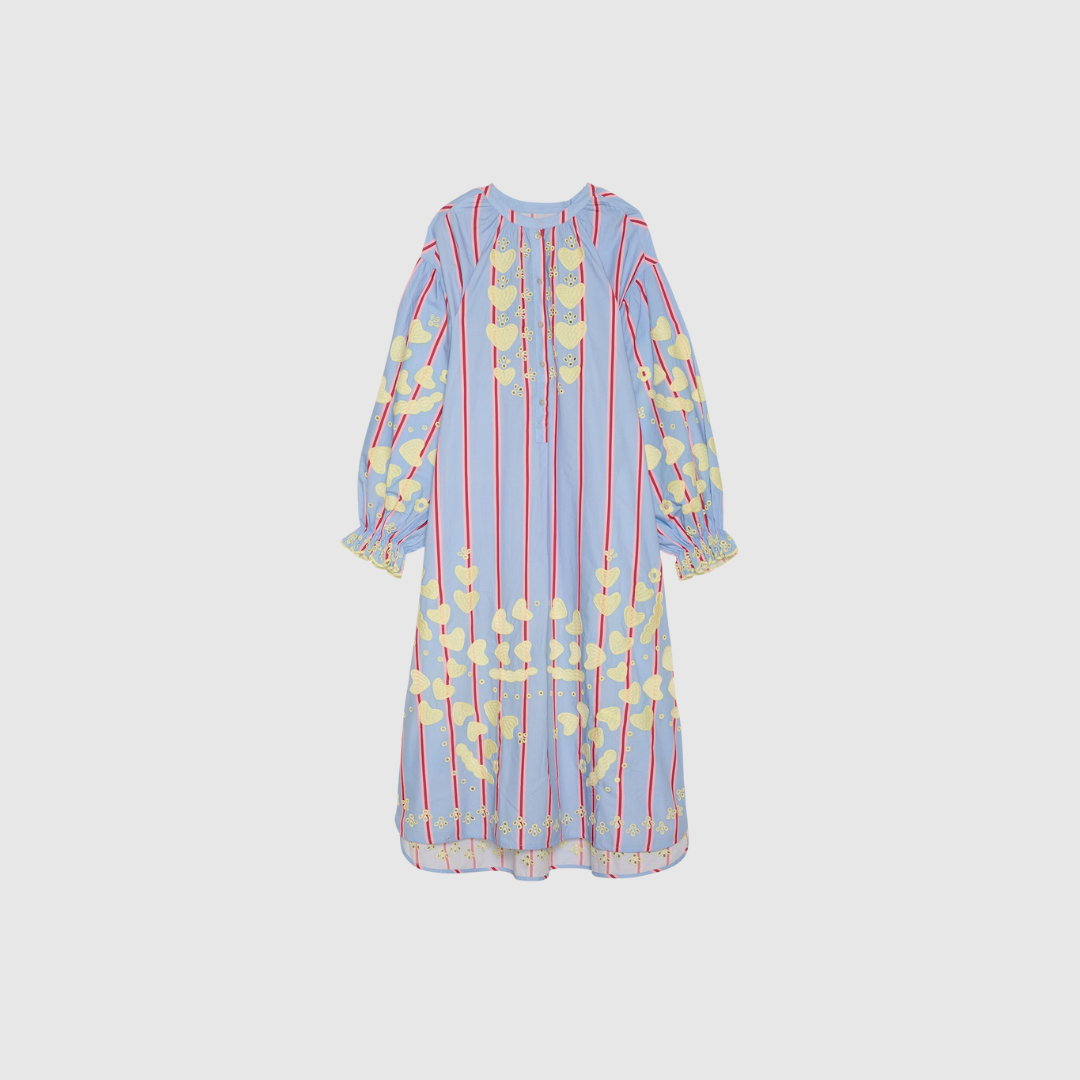 Opdag Elisabeth Dress fra Sissel Edelbo – en rummelig og feminin maxikjole i 100% økologisk cotton poplin. Med de fine hjertebroderier, voluminøse ærmer og klassiske perlemorsknapper får kjolen et eksklusivt og romantisk udtryk. Farven Bluebell Stripes gør den frisk og tidløs, perfekt til både hverdagsbrug og særlige anledninger. En smuk, let og bæredygtigt produceret style.