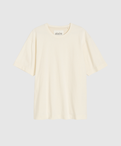 Opdag Lui Circular Tee – Pure Ecru, en klassisk T‑shirt i en kraftig og blød jersey af 50% økologisk og 50% genanvendt bomuld. Inspireret af menswear og designet i en let oversized pasform med rund hals og broderet Aiayu‑logo. Fremstillet i Portugal som en del af et cirkulært produktionssystem, der genanvender restmaterialer og fremstiller nyt, ansvarligt tekstil. En kvalitetsbevidst og bæredygtig basic, der passer til enhver garderobe.