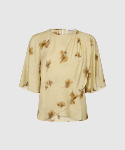 MylaCC Flower Drape SS Blouse i Pale Yellow er en let og feminin bluse med draperet silhuet. Korte ærmer og smukt fald i en blød viskose/polyamid‑blanding. Perfekt til forårs‑ og sommerstyles.