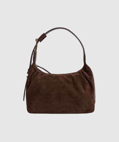 Opdag Madrid Handbag i farven Chocolate – en elegant taske i ruskind og glat koskind. Med magnetisk lukning, justerbar rem og praktisk indretning er tasken både funktionel og luksuriøs. Perfekt til både hverdag, kontor og festlige lejligheder.