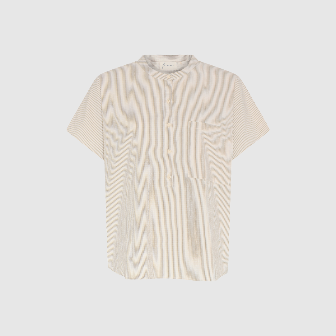 Colombo SS Top – Tapioca Coffee fra FRAU er en kortærmet top i 100% økologisk bomuld med kinakrave, halv stolpelukning og brystlomme. En afslappet og moderne hverdagsstyle i en smuk, rolig farvekombination.