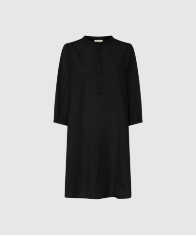 Madrid Kort Kjole – Black fra FRAU er en knælang, let skjortekjole i 100% økologisk bomuld med kinakrave, halv stolpelukning, sidelommer og 3/4‑ærmer. En tidløs og komfortabel style, der passer til både hverdag og mere pæne anledninger.