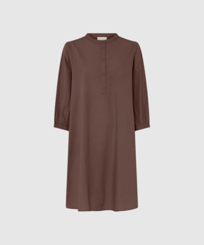 Madrid Kort Kjole – Coffee Quartz fra FRAU er en knælang skjortekjole i 100% økologisk bomuld. Med kinakrave, halv stolpelukning, sidelommer og rummelige 3/4‑ærmer får du en tidløs, feminin og komfortabel kjole, der fungerer året rundt.