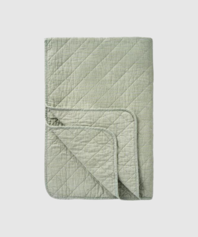Opdag den klassiske quilt med hvide og støvet grøn mælkedrengestriber fra Ib Laursen – et smukt og hyggeligt tæppe i blød bomuld med quiltet struktur. Den tidløse kombination af blå og hvid giver et rent, nordisk look, som passer perfekt i stuen, soveværelset eller sommerhuset. Brug den som plaid, sengetæppe, picnic‑tæppe eller som ekstra hygge på terrassen.