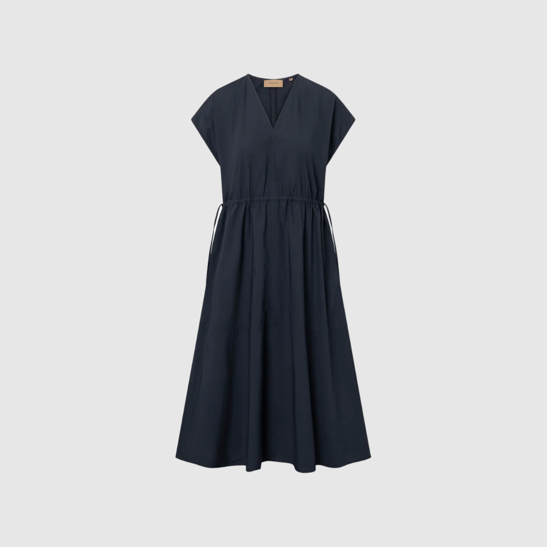 Rue de Tokyo Dalila GMTD Poplin Dress Dark Navy er en elegant skjortekjole i 100% bomuldspoplin. Den garment‑dyed navy farve giver et eksklusivt og tidløst udtryk, mens den afslappede pasform og de lange ærmer gør kjolen perfekt til både hverdag og arbejde. Et minimalistisk, luksuriøst design i høj kvalitet.