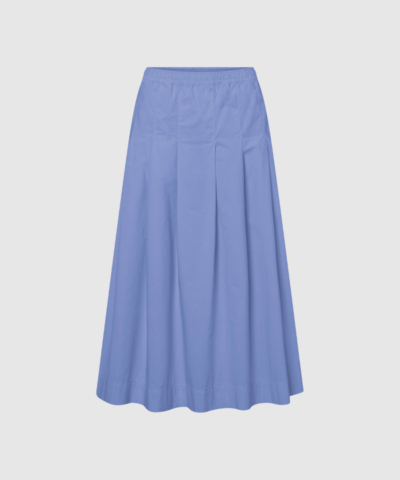 Rue de Tokyo Polly GMTD Poplin Skirt i Blue Bonnet er en elegant og tidløs nederdel i 100% bomuldspoplin. Med elastisk talje, let fald og en smuk garment‑dyed blå farve er den perfekt til både hverdag og pænere anledninger. En feminin og alsidig style fra Rue de Tokyos nye kollektion.