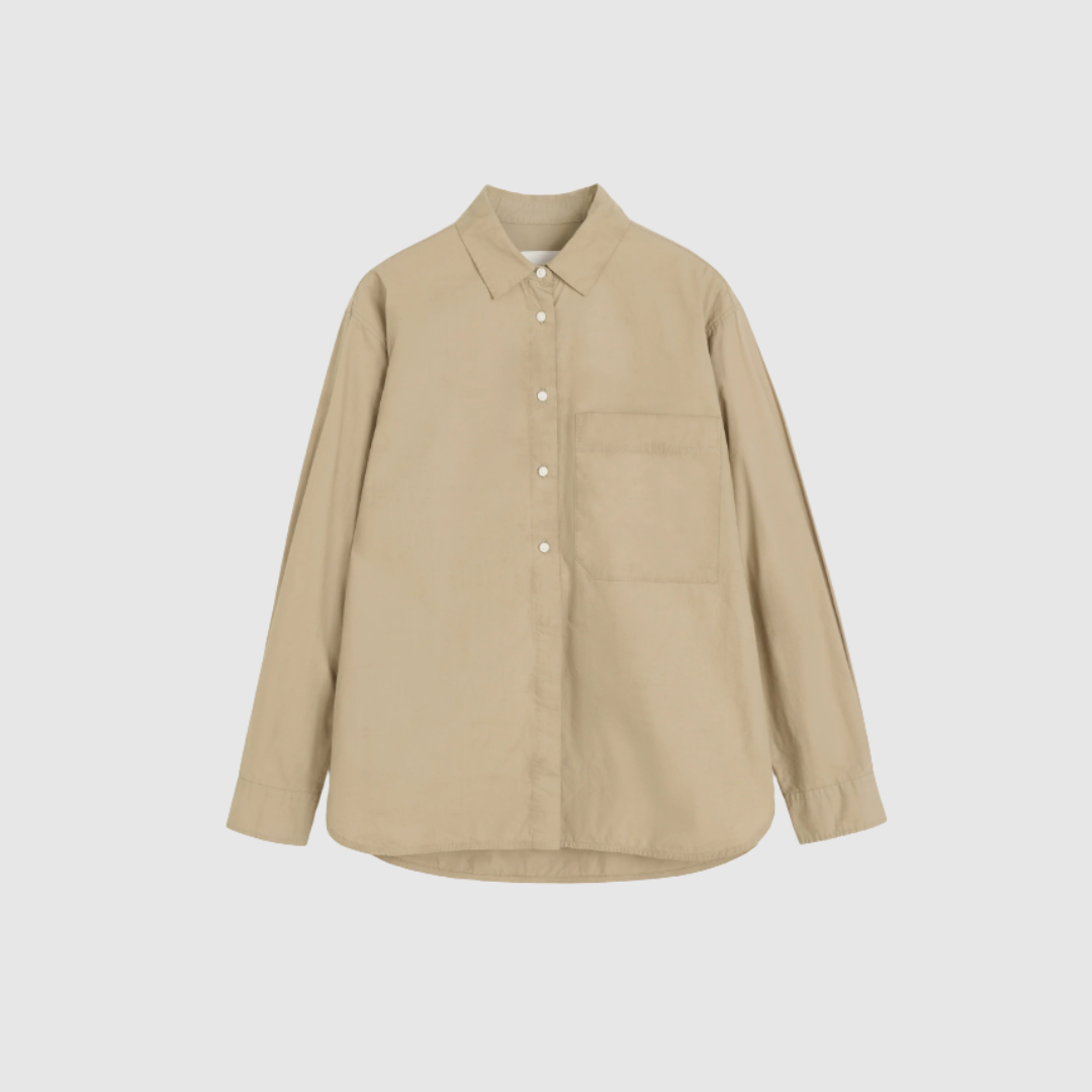 Aiayu Lynette Shirt i Semolina er en elegant skjorte i 100% GOTS‑certificeret økologisk bomuld. Den voluminøse silhuet, ekstra længde bagtil og brede manchetter skaber et feminint og tidløst udtryk. Skjorten er produceret i regenerativ bomuld, der både gavner miljøet og føles luksuriøs mod huden. Et perfekt valg til dig, der ønsker kvalitet, design og bæredygtighed i ét.