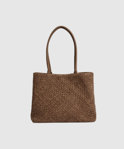 Berlin Handbag i farven Mud er en luksuriøs håndflettet ruskindstaske med et eksklusivt og tidløst udtryk. Den rummelige form, faste skulderrem og velorganiserede indvendige lommer gør den perfekt til både hverdag og pænere anledninger. Et smukt kvalitetsprodukt i blødt ruskind, skabt til dig der søger både funktionalitet og eksklusivt håndværk.