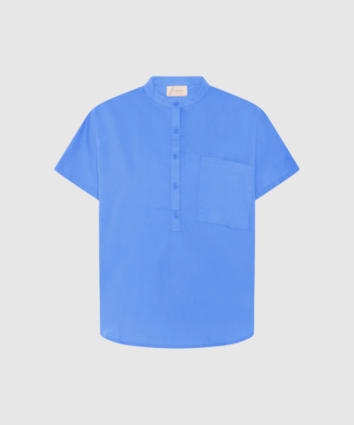 Colombo Top fra FRAU i Granada Sky er en let og komfortabel kortærmet top i 100% økologisk bomuld. Med kinakrave, halv stolpelukning og et luftigt oversized fit er den perfekt til både hverdag og afslappede sommerdage. Find den hos Merci Give.