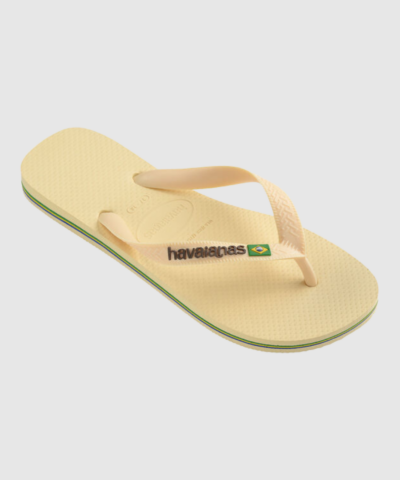 Havaianas Brasil Logo i Buttercream er en klassisk flip‑flop i 100% gummi med logo‑rem, brasiliansk flag og farvet sålkant. Let, fleksibel og slidstærk – perfekt til sommer, strand, hverdag og rejser. Den bløde cremafarve passer til alle outfits og giver et elegant, minimalistisk look.
