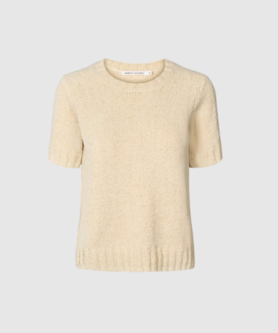 Elka Towelling Knit T-shirt i sand fra Rabens Saloner er en kortærmet luksusstrik i blød towelling‑kvalitet. Med regular fit, rund hals og ribdetaljer får du en elegant, alsidig og komfortabel T-shirt, som er perfekt til både hverdagsbrug og sæsonens mere stilrene outfits.