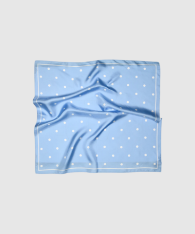 Paloma Silk Scarf i blå med hvide polkaprikker. Et feminint og tidløst silketørklæde i 100% silke – perfekt til både hverdags- og feststyling.