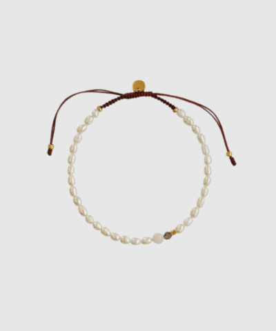 Lumi Bracelet er et elegant, håndknyttet armbånd med ferskvandsperler, røgkvarts og pink opal. Fremstillet med 18 kt. forgyldt sterlingsølv og stærkt nylon, og perfekt som både solo‑smykke og til stacking. Justerbar omkreds 17–25 cm. Et naturligt, feminint og luksuriøst armbånd fra STINE A Jewelry.