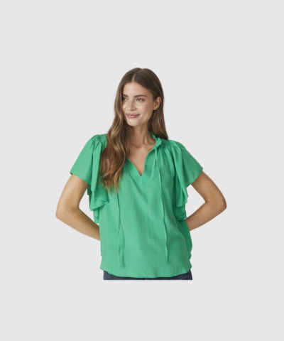 SunriseCC SS Frill Top er en feminin top med flæsedetaljer i let viskoseblanding. En elegant og komfortabel top i grøn farve, perfekt til både hverdag og pænere brug. Find SunriseCC toppen hos Merci Give.