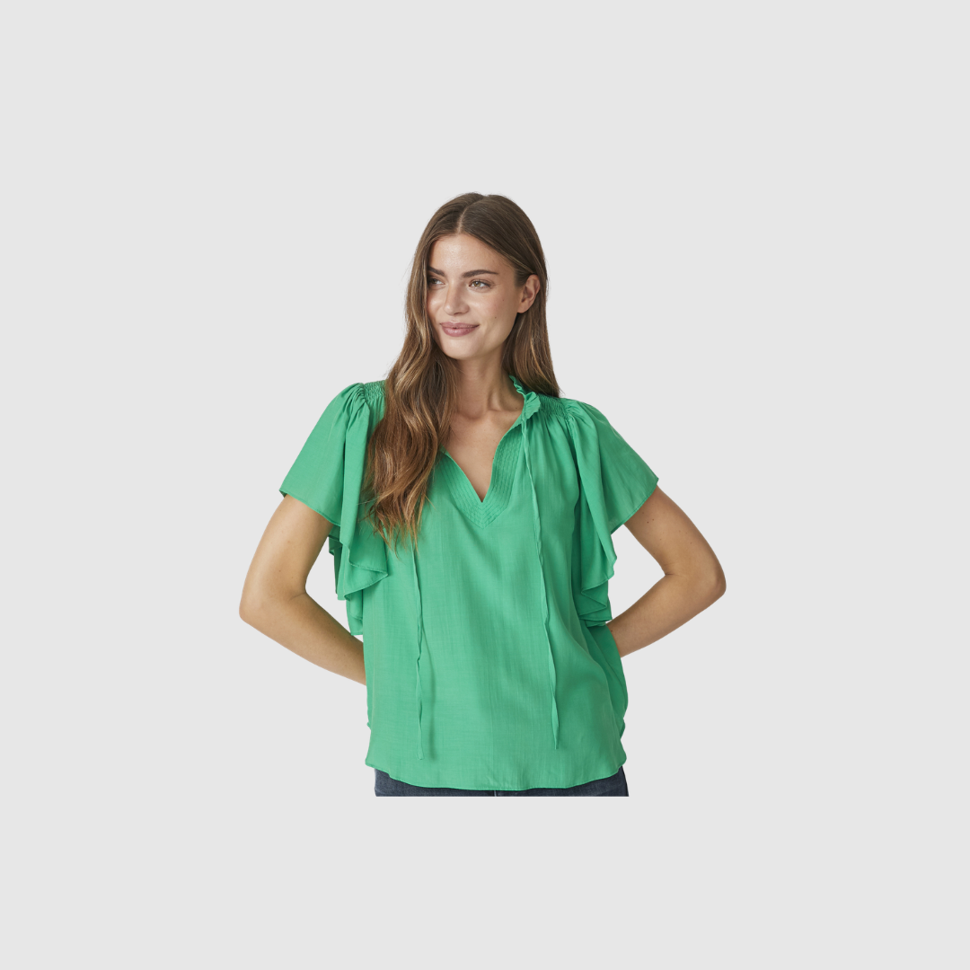 SunriseCC SS Frill Top er en feminin top med flæsedetaljer i let viskoseblanding. En elegant og komfortabel top i grøn farve, perfekt til både hverdag og pænere brug. Find SunriseCC toppen hos Merci Give.