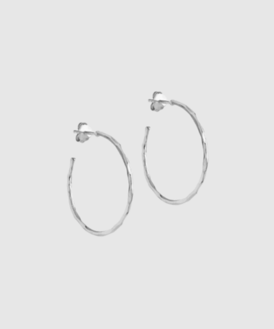 Organic Arena Medium Hoops fra ENAMEL Copenhagen er klassiske sølv‑hoops i sterlingsølv med organisk, hamret overflade. Et elegant og anvendeligt smykke, perfekt til både hverdag og pænere anledninger. Find Organic Arena Hoops hos Merci Give.