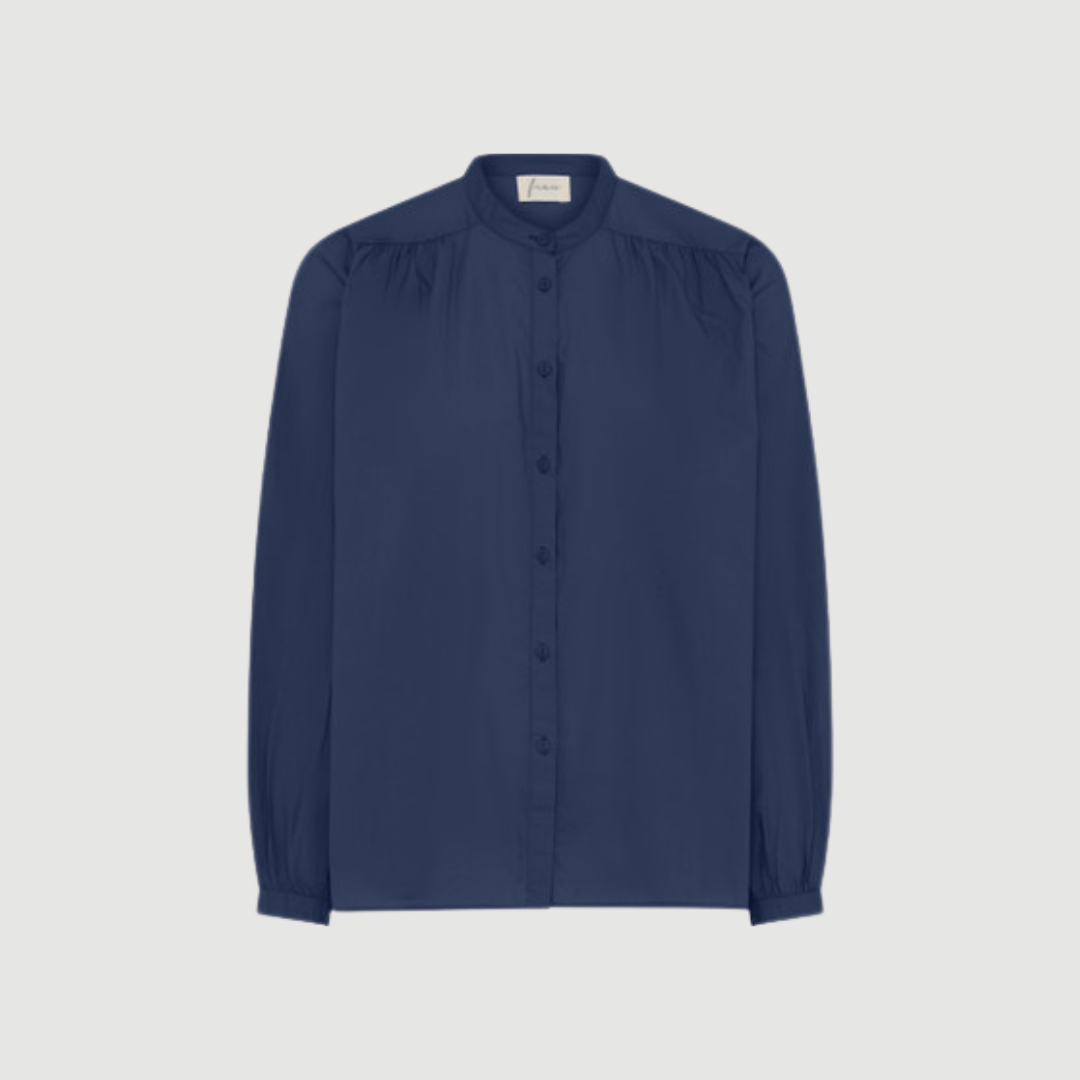 Florence Skjorte fra FRAU i farven Navy Blazer (India Ink) er en klassisk onesize skjorte i 100 % økologisk bomuld. Skjorten har kinakrave, lange ærmer og fine rynkedetaljer, som giver et feminint og tidløst udtryk. En alsidig skjorte til både hverdag og pænere brug. Find FRAU Florence Skjorte hos Merci Give.