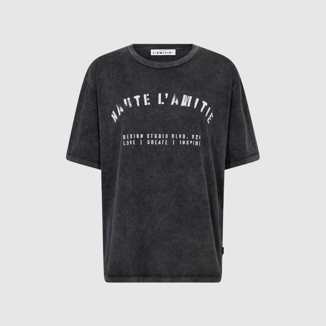 Noma Acid Curve Studio Tee i Black Acid Wash er en cool T‑shirt i 100 % bomuld med rå acid wash‑effekt. En moderne og afslappet tee, perfekt til hverdagsbrug og casual styling. Find Noma Studio Tee hos Merci Give.