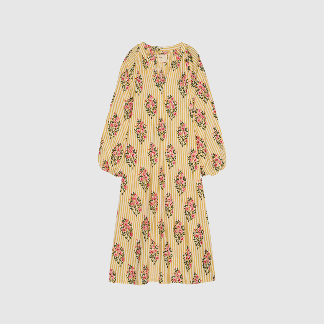 Lara Dress i Golden Yellow er en lang kjole i 100 % økologisk bomuld med håndlavet block print. En luftig kjole med V‑udskæring, ballonærmer og afslappet pasform. Perfekt til både hverdag og sommerens anledninger. Find Lara Dress hos Merci Give.