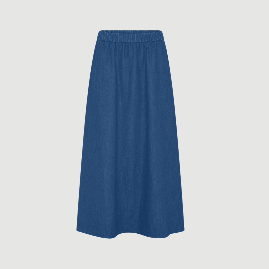 Melbourne Ankellang Denim Nederdel fra FRAU i farven Clear Blue Denim er en tidløs og enkel denimnederdel i 100 % økologisk bomuld. Nederdelen har elastisk talje, justerbar snøre og ankellang pasform, der giver et afslappet og brugbart look til både hverdag og fritid. Find FRAU Melbourne denim nederdel hos Merci Give.