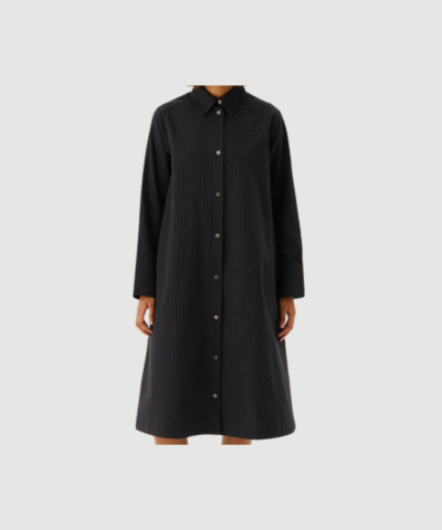 DARIAN Wide Seersucker Dress fra Rue de Tokyo i navy er en elegant skjortekjole i 100 % bomuld med seersucker‑struktur, klassisk krave og gennemknapning. En let og tidløs kjole, perfekt til både hverdag og mere pæne anledninger.