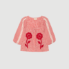 Abelone Top fra SISSEL EDELBO er en feminin top i 100 % økologisk bomuld med Suzani-inspireret broderi og ballonærmer. En unik og dekorativ bluse med løs pasform, perfekt til både hverdag og sommerstyles.