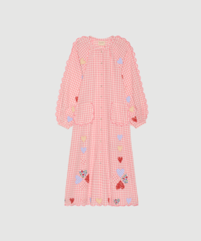 Kamal Dress fra SISSEL EDELBO er en feminin kjole i pink tern fremstillet i 100 % økologisk bomuld. Kjolen har voluminøse ærmer, broderede scallop‑kanter, perlemorsknapper og fine hjerteapplikationer, som giver et unikt og kunstnerisk udtryk. En elegant statement‑kjole med bæredygtigt fokus.