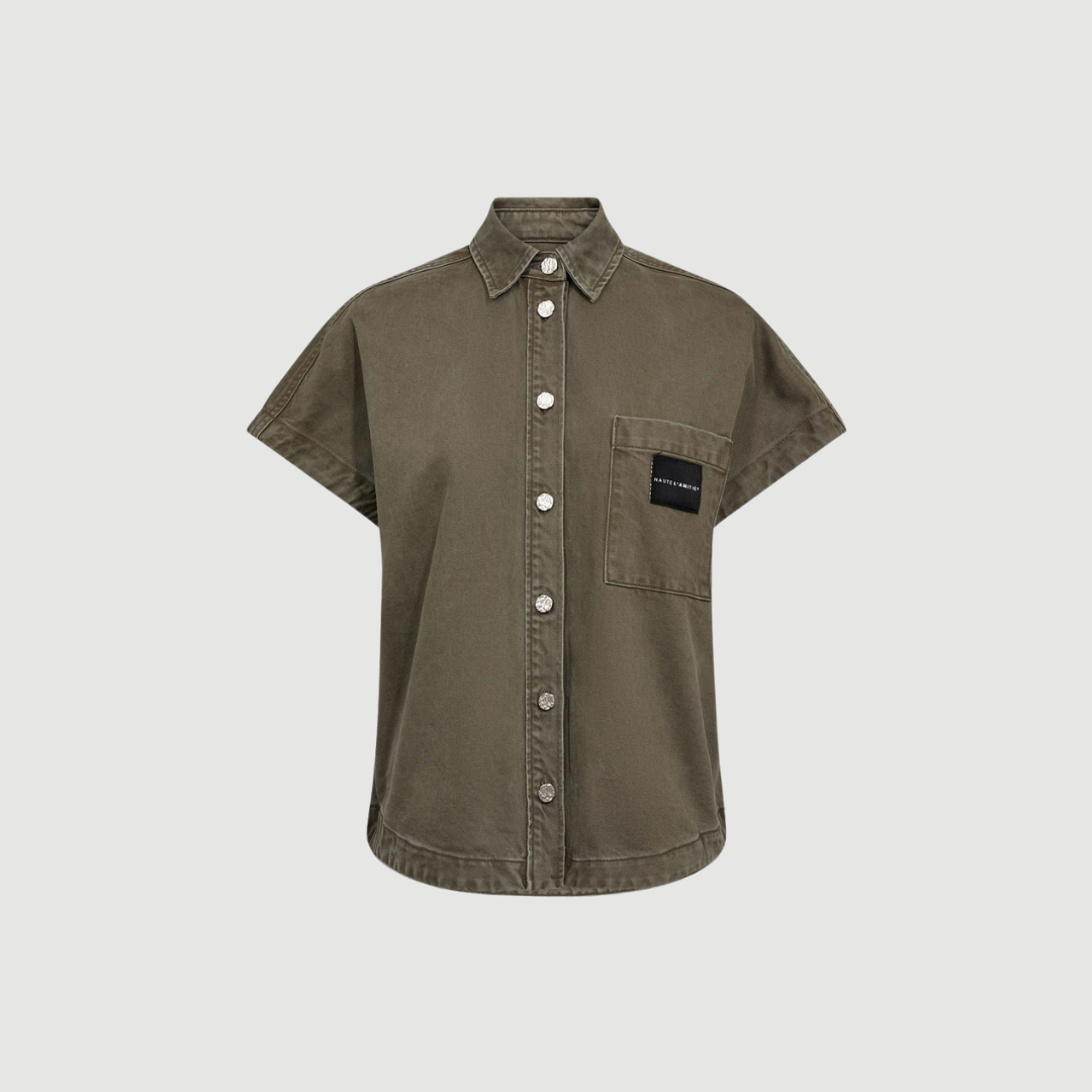 Enigma NS Logo Shirt i mud er en ærmeløs skjorte med afslappet pasform og blød bomuld/lyocell kvalitet. En stilren og moderne style perfekt til hverdag og layering.