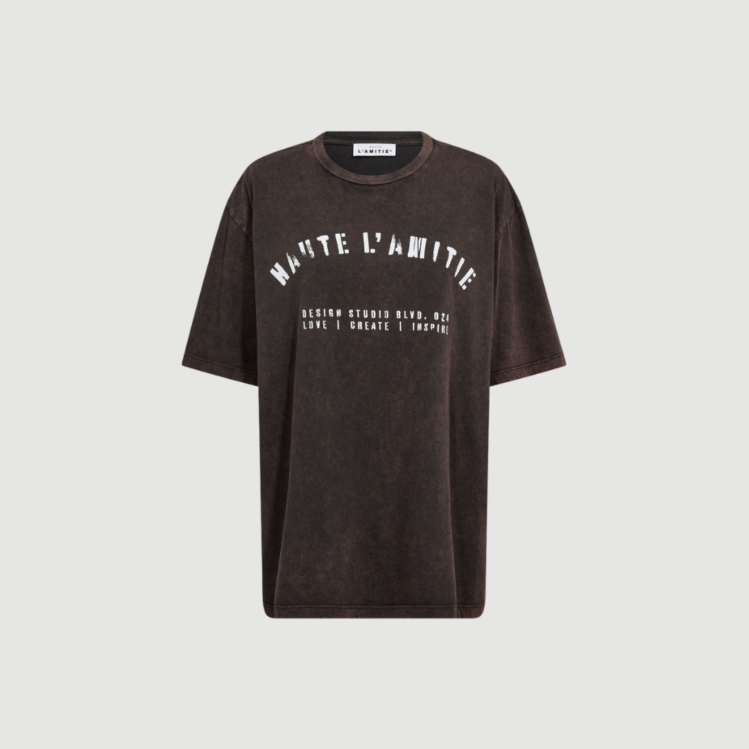 Noma Acid Curve Studio Tee fra Haute L’Amitié i Mocca Acid Wash er en afslappet T‑shirt med vintage‑inspireret acid wash effekt. En moderne og komfortabel style til hverdagsbrug.