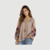 Isadora Shirt i sand er en feminin bomuldsbluse med broderede blomster, bindebånd og stribet design. En romantisk og boheme-inspireret bluse perfekt til hverdag og sommer.